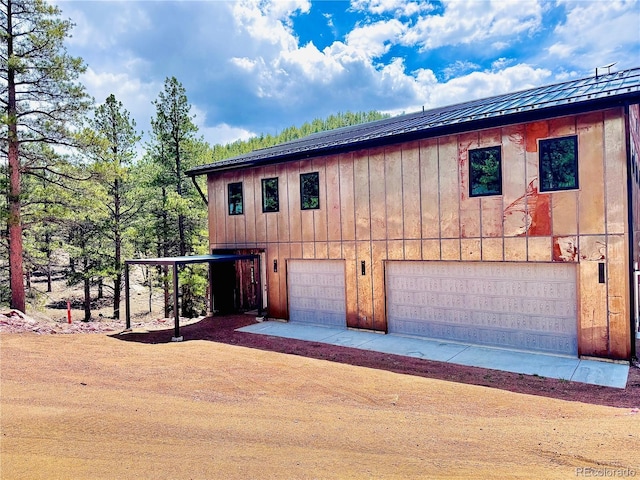 1282 N Crystal Rd, Lake George, CO 80827 - view of home's exterior featuring board and batten siding, a garage, driveway, and metal roof