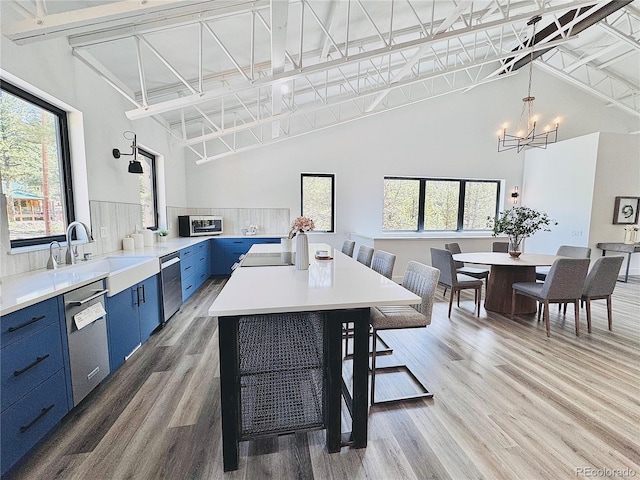 1282 N Crystal Rd, Lake George, CO 80827 - kitchen featuring blue cabinetry, stainless steel dishwasher, a chandelier, high vaulted ceiling, and light countertops