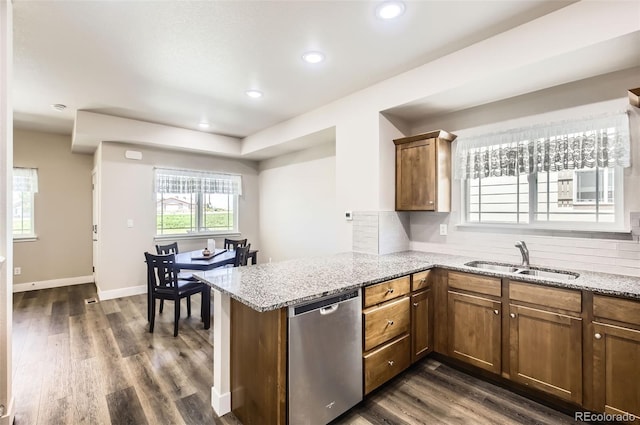 1746 Westward Cir Unit 1, Eaton, CO 80615 - kitchen featuring dishwasher, a peninsula, backsplash, dark wood finished floors, and light stone countertops