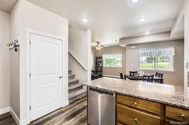 1746 Westward Cir Unit 1, Eaton, CO 80615 - kitchen featuring stainless steel dishwasher, dark wood-style floors, brown cabinets, ceiling fan, and light stone countertops