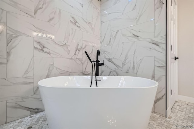 bathroom with a freestanding bath and tile walls
