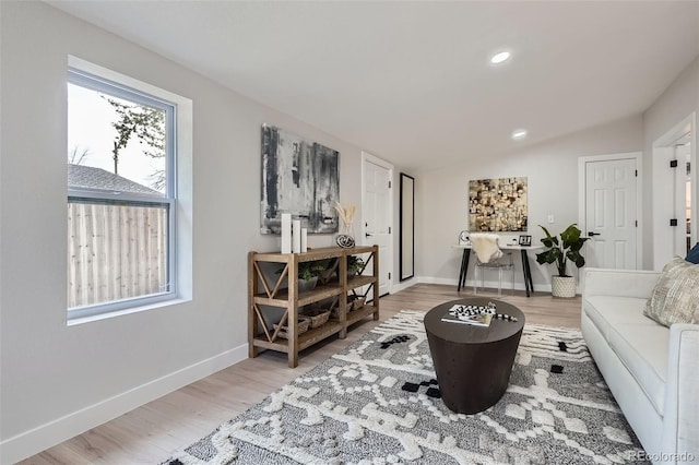 living area with recessed lighting, baseboards, vaulted ceiling, and light wood-style flooring