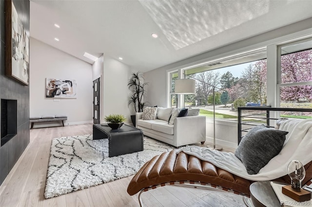 living room with baseboards, vaulted ceiling, wood finished floors, and recessed lighting
