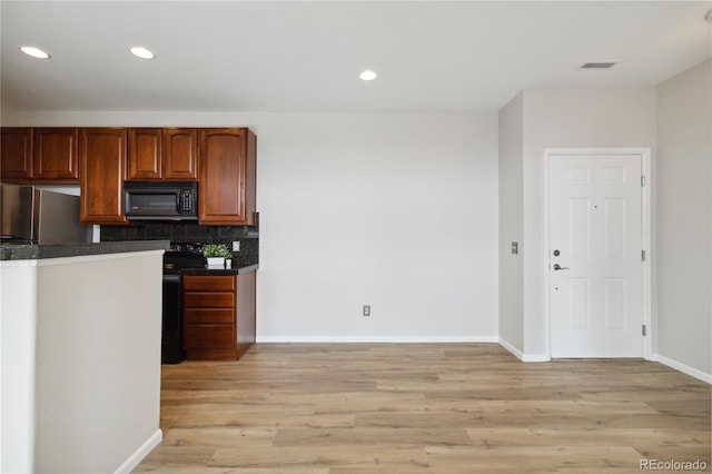 kitchen featuring black appliances, dark countertops, light wood-style flooring, baseboards, and recessed lighting