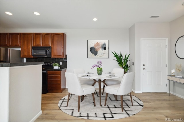 dining room with light wood-type flooring, baseboards, and recessed lighting