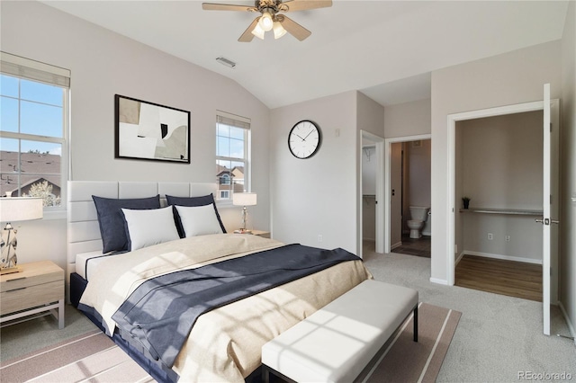 carpeted bedroom with vaulted ceiling, baseboards, ensuite bath, and ceiling fan