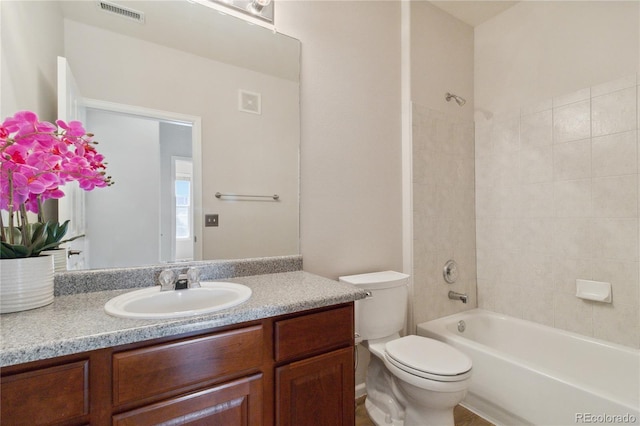 bathroom featuring toilet, vanity, and bathtub / shower combination