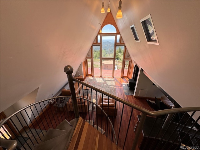 stairway with lofted ceiling and hardwood / wood-style floors