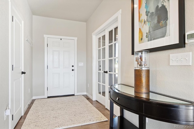 entryway with wood finished floors and baseboards