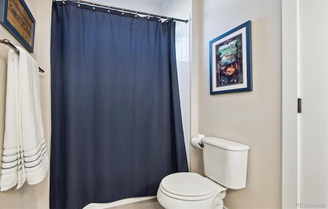 bathroom featuring curtained shower and toilet