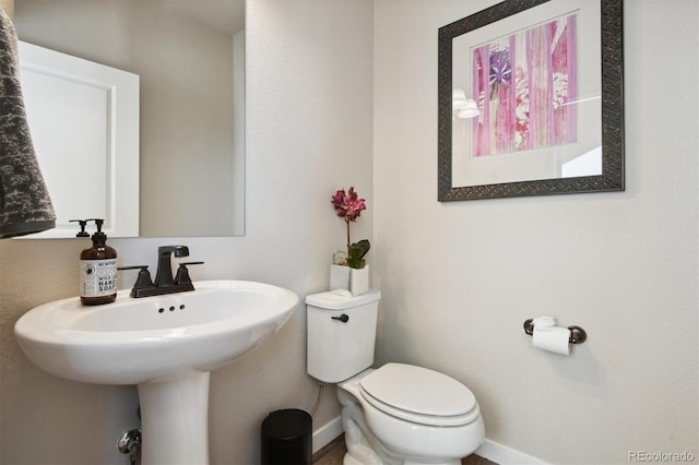bathroom with toilet and baseboards