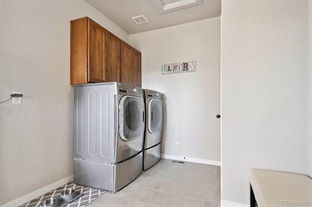 washroom with visible vents, baseboards, washer and dryer, and cabinet space