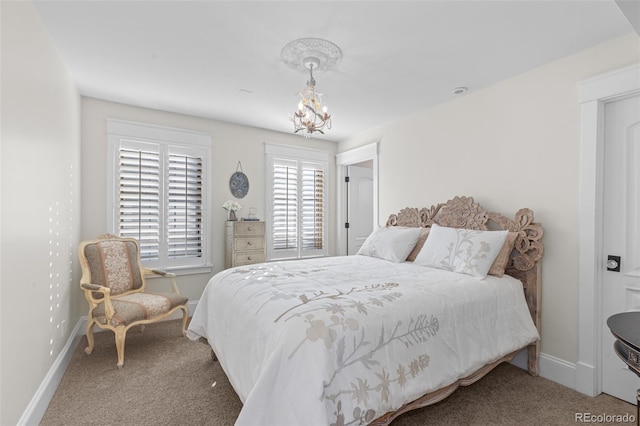 carpeted bedroom featuring baseboards and an inviting chandelier