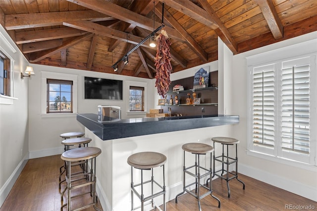 kitchen featuring wooden ceiling, lofted ceiling with beams, baseboards, and wood finished floors