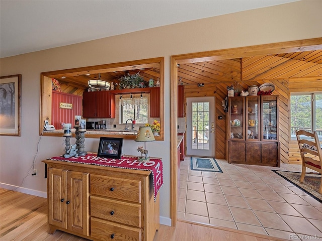 kitchen with baseboards, light wood-style flooring, and a sink