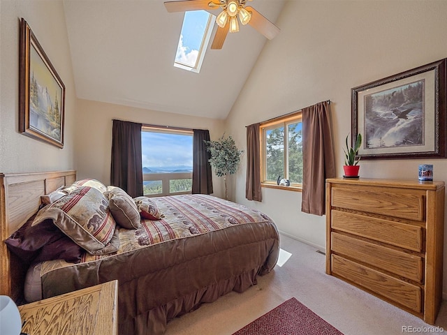 carpeted bedroom with a skylight, multiple windows, high vaulted ceiling, and ceiling fan