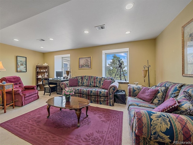 living area featuring visible vents, recessed lighting, and light carpet