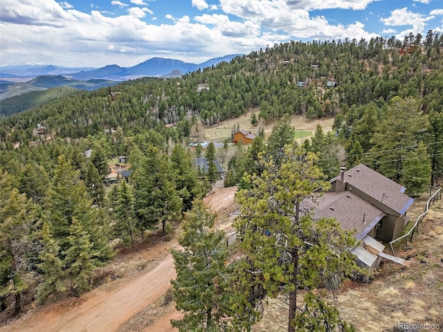drone / aerial view with a mountain view and a view of trees