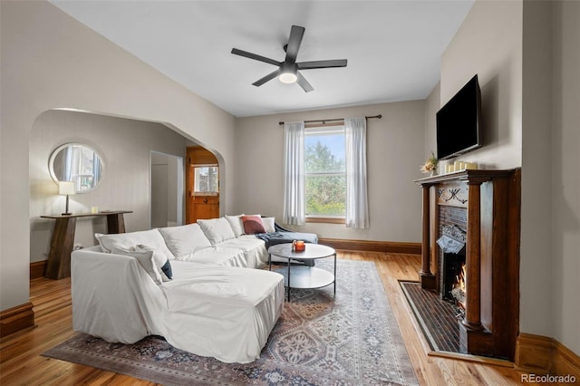 14 S Lincoln St Unit 16, Denver, CO 80209 - living area featuring a fireplace, ceiling fan, arched walkways, and wood finished floors