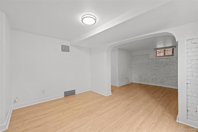 14 S Lincoln St Unit 16, Denver, CO 80209 - unfurnished room featuring brick wall, light wood finished floors, and a textured ceiling