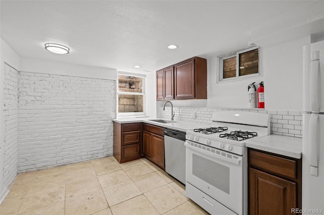 14 S Lincoln St Unit 16, Denver, CO 80209 - kitchen with white appliances, brick wall, light countertops, decorative backsplash, and recessed lighting