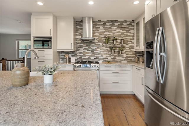 5292 W Fair Dr, Littleton, CO 80123 - kitchen with appliances with stainless steel finishes, range hood, glass insert cabinets, recessed lighting, and white cabinets