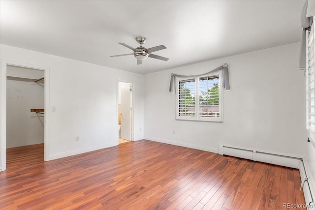 591 Nome St, Aurora, CO 80010 - unfurnished bedroom with a baseboard heating unit, wood finished floors, a walk in closet, ceiling fan, and ensuite bathroom