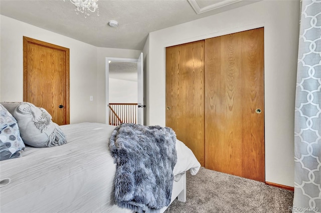 carpeted bedroom featuring a closet and a textured ceiling