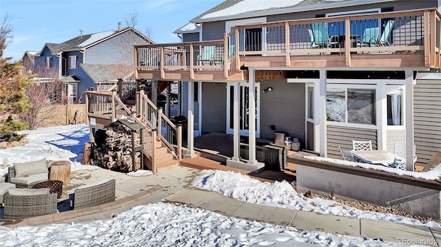 snow covered house featuring a deck