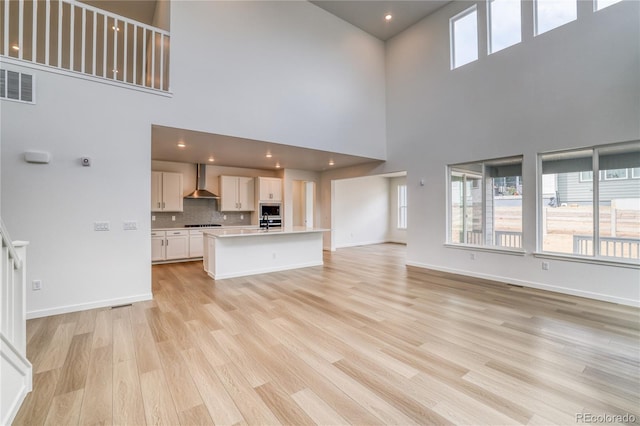 8595 Silverton Ln, Littleton, CO 80125 - unfurnished living room with a high ceiling and light wood-type flooring