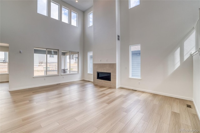 8595 Silverton Ln, Littleton, CO 80125 - unfurnished living room with a high ceiling, a healthy amount of sunlight, and light hardwood / wood-style floors
