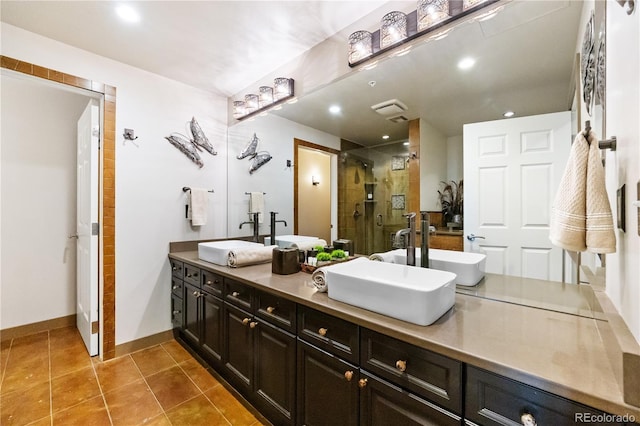 bathroom featuring a stall shower, tile patterned floors, baseboards, double vanity, and recessed lighting