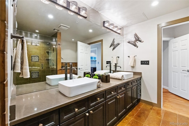 full bath featuring tile patterned floors, double vanity, tiled shower, recessed lighting, and baseboards