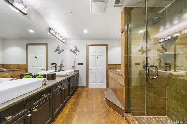 bathroom with a stall shower, tile patterned flooring, double vanity, and recessed lighting