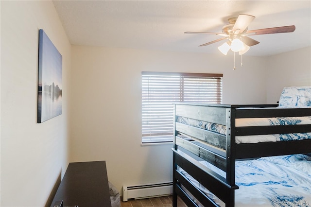 bedroom with ceiling fan, light wood-type flooring, and a baseboard heating unit