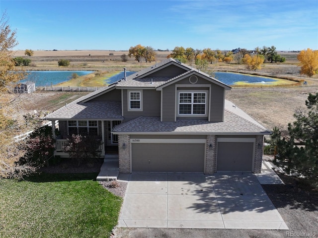 view of front of house featuring a garage, a water view, and a front yard