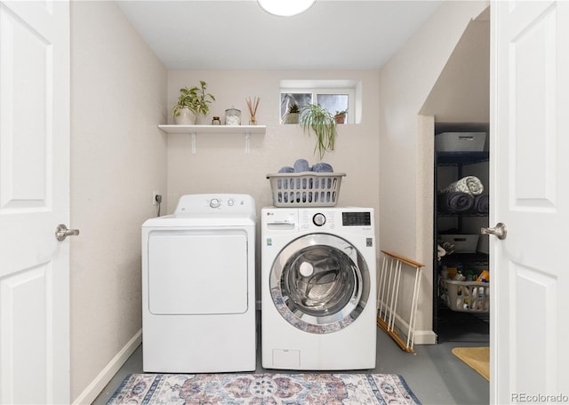 laundry area with separate washer and dryer and baseboards