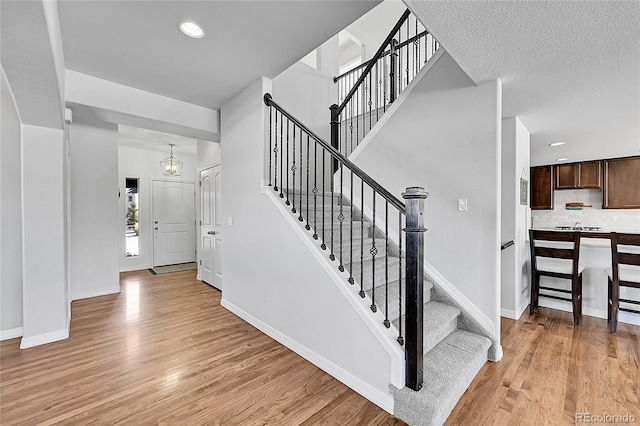 foyer entrance with light hardwood / wood-style flooring and a textured ceiling