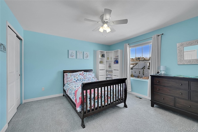 carpeted bedroom with ceiling fan and a closet