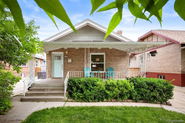 1532 Meade St, Denver, CO 80204 - view of front of house featuring covered porch, brick siding, and a chimney