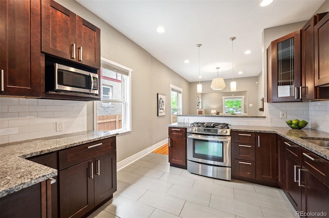 1532 Meade St, Denver, CO 80204 - kitchen with appliances with stainless steel finishes, a peninsula, tasteful backsplash, baseboards, and light stone counters