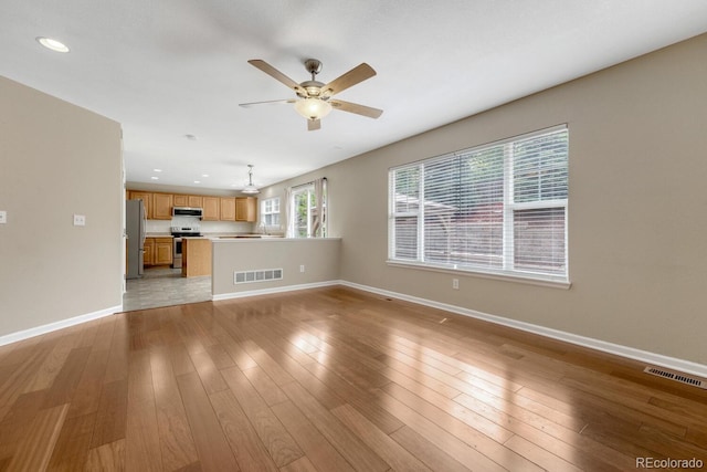unfurnished living room featuring a ceiling fan, baseboards, recessed lighting, and light wood-style floors