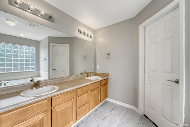 full bath featuring tile patterned floors, double vanity, and baseboards