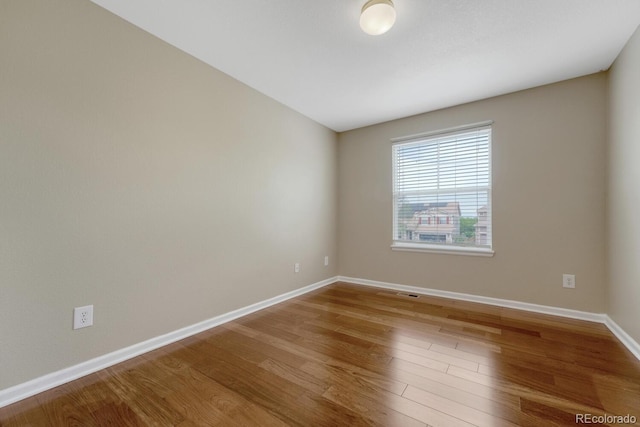 empty room featuring wood finished floors and baseboards