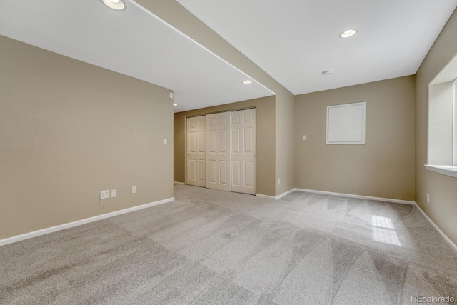 unfurnished bedroom with carpet, recessed lighting, baseboards, and a closet