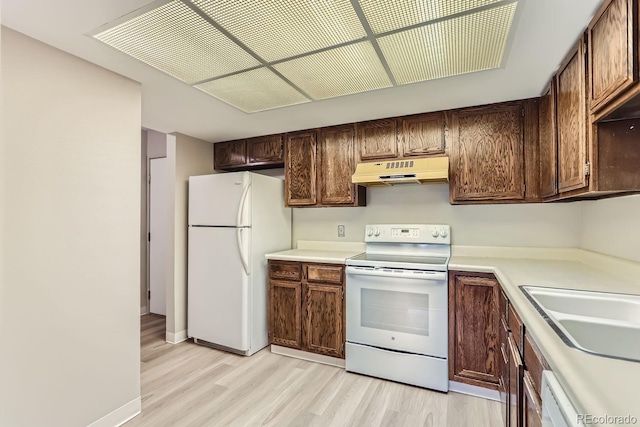 kitchen with white appliances, light hardwood / wood-style floors, and sink