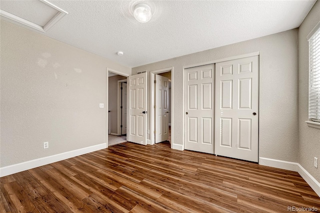 unfurnished bedroom featuring a textured ceiling, hardwood / wood-style flooring, and a closet