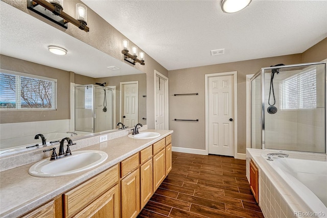 bathroom featuring vanity, plus walk in shower, and a textured ceiling