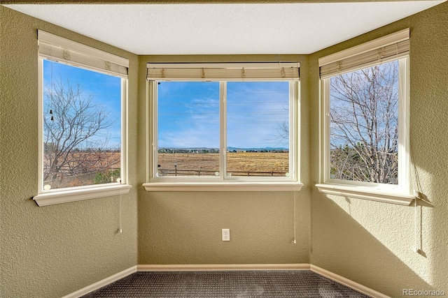 empty room with carpet flooring and a textured ceiling