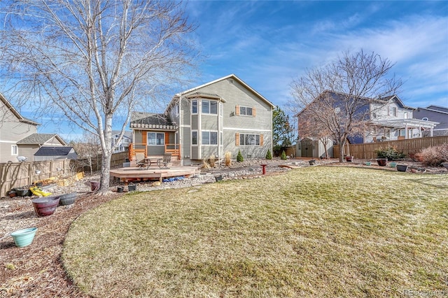 back of house featuring a wooden deck, a yard, and a storage unit